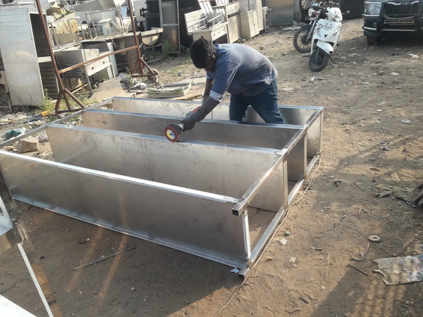 Stainless steel kitchen trough being finished by a fabricator
