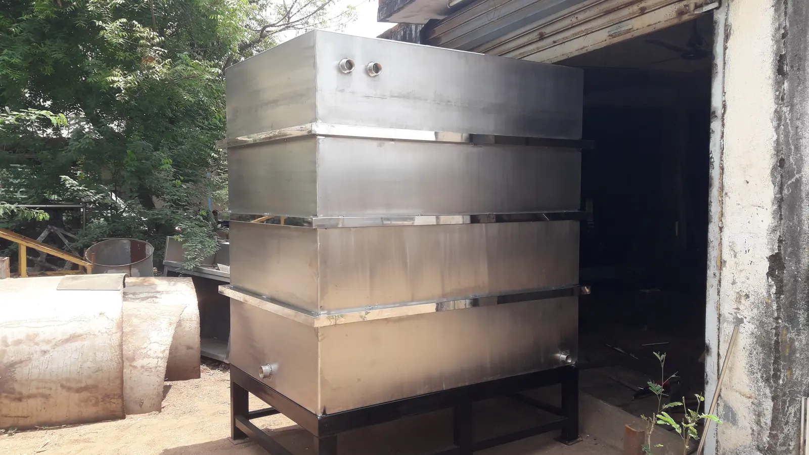 Large fabricated stainless steel storage tank on a structural steel base